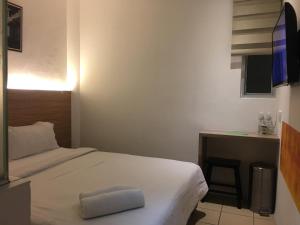 een kleine slaapkamer met een bed en een bureau bij Place2Stay @ Kenyalang in Kuching