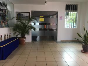 Un vestíbulo con plantas en macetas en un edificio. en Place2Stay @ Kenyalang, en Kuching 3 fotos más