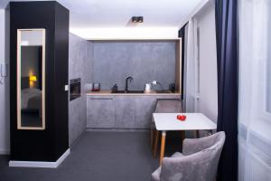 kuchnia z białym stołem i zlewem w obiekcie Silesia Apartments w mieście Katowice +37 zdjęć