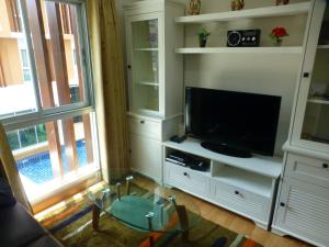 a living room with a tv and a glass table at 1 Double bedroom Apartment with Swimming pool security and high speed WiFi in Udon Thani