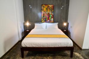 - une chambre avec un grand lit et deux lampes dans l'établissement Villa Grange, à Phnom Penh