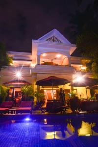 a villa with a swimming pool at night at Villa Grange in Phnom Penh