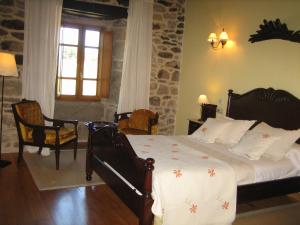 1 dormitorio con 1 cama en una habitación con ventana en Pazo A Freiria en Puebla de Trives