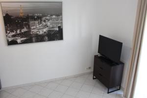 sala de estar con TV y una foto en la pared en Residence Enzo Paradise, en La Seyne-sur-Mer