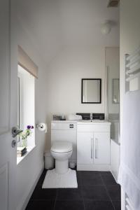 a white bathroom with a toilet and a sink at First floor flat with parking in Wheatley