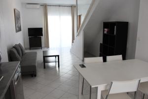 ein Wohnzimmer mit einem weißen Tisch und Stühlen in der Unterkunft Residence Enzo Paradise in La Seyne-sur-Mer