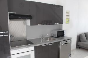 cocina con fregadero y microondas en Residence Enzo Paradise, en La Seyne-sur-Mer