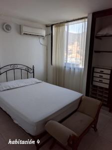 1 dormitorio con 1 cama, 1 silla y 1 ventana en Penthouse En El Rodadero, en Santa Marta