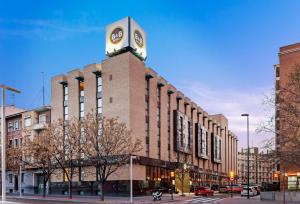 un edificio con una torre de reloj encima en B&B HOTEL Zaragoza Los Enlaces Estación en Zaragoza