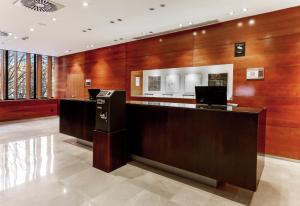 an office lobby with wood paneling and a reception desk at B&B HOTEL Zaragoza Los Enlaces Estación in Zaragoza