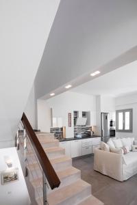 sala de estar blanca con sofá y escalera en Alchemy Villa - Prive Pool, en Megalokori