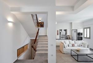 Una sala de estar blanca con un sofá y una mesa. en Alchemy Villa - Prive Pool, en Megalokori