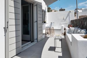 una casa con un pequeño balcón con mesa y sillas. en Alchemy Villa - Prive Pool, en Megalokori