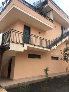 a building with a balcony and a staircase on it at Casa degli Oleandri in Roccalumera