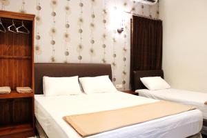 a room with two beds and a desk and a bed sidx sidx sidx at House of Dharmawan in Surabaya