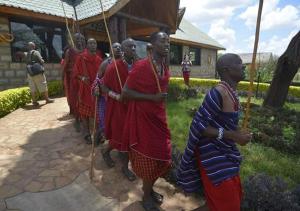 a group of men in red uniforms standing in front of a house at AA Lodge Amboseli in Amboseli
