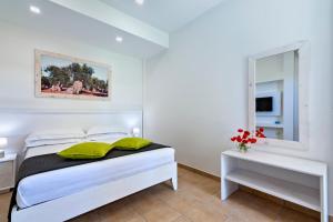 a white bedroom with a bed and a mirror at Olive Garden House in Borgagne +40 photos