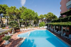 a large swimming pool with chairs and trees at Hotel Meeting in Cesenatico