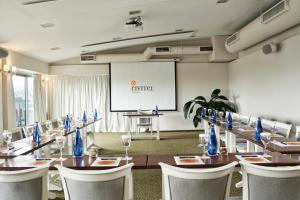 a conference room with a table and chairs and a screen at Civitel Olympic in Athens