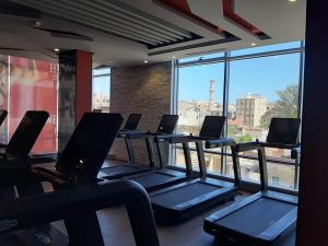a row of treadmills in a gym with a window at Exoticky apartman in Hurghada