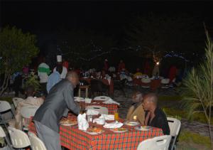 un grupo de personas sentadas en una mesa comiendo comida en AA Lodge Maasai Mara en Talek