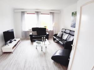 a living room with black furniture and a table at Ferienwohnung Albstadt Panorama in Albstadt