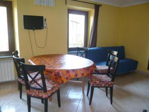 Habitación con mesa, sillas y TV. en AGRITURISMO Cré Seren, en Susa