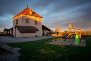 une maison avec une aire de jeux en face d'un bâtiment dans l'établissement Gite Du Colombier, à Le Fied