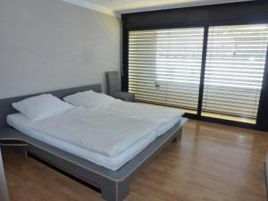 Bett in einem Zimmer mit einem großen Fenster in der Unterkunft Casa Rana in Ascona