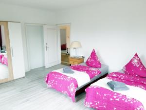 a room with two beds with pink sheets and a mirror at Ferienwohnung Albstadt Panorama in Albstadt