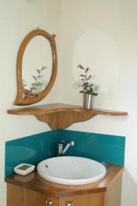 a bathroom with a sink and a mirror on a counter at Joya Garden & Villa Studios in Nelson