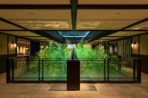 a large green wall in a lobby with a sculpture at Dhawa Yura Kyoto in Kyoto