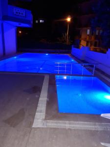 a swimming pool at night with blue water at Aygun Apart Daire in Mahmutlar
