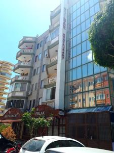a white car parked in front of a building at Aygun Apart Daire in Mahmutlar