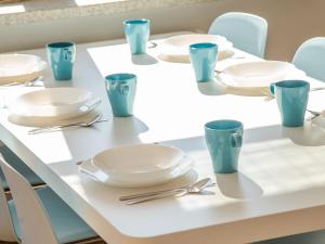 uma mesa com pratos e utensílios em Apartamenty Lighthouse - Jantar 20 em Kolobrzeg