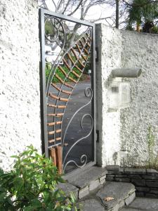 una puerta abierta con una puerta de espiral metálica en Joya Garden & Villa Studios en Nelson