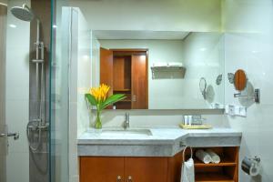 a bathroom with a sink and a mirror at Oak Tree Emerald Semarang Managed by The Ascott Limited in Semarang