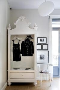 Un hutte blanche avec des vêtements suspendus dans une pièce dans l'établissement Rosso Segnale Milano, à Milan