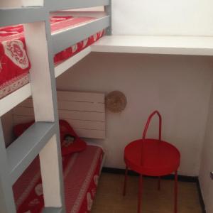 a small room with a red stool and bunk beds at Super Dévoluy, Résidence le Bois D'Aurouze in Le Dévoluy