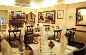 een eetkamer met witte tafels en stoelen bij Maria Suite am Dom in Keulen