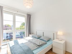 - une chambre blanche avec un lit et une fenêtre dans l'établissement Apartamenty Lighthouse - Jantar 20, à Kołobrzeg