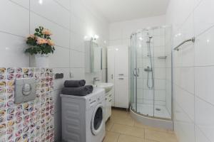 biała łazienka z prysznicem i pralką w obiekcie Apartament Gdańsk z balkonem Stare Miasto w Gdańsku