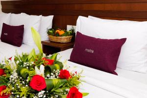 een bed met rode rozen en een mand met bloemen bij Metro Hotel @ KL Sentral in Kuala Lumpur