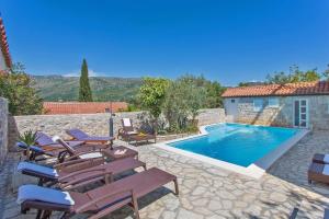 a villa with a swimming pool with chairs and a house at Villa Imperial View in Zaton