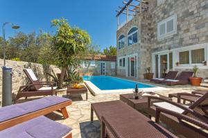 a patio with chairs and a swimming pool at Villa Imperial View in Zaton