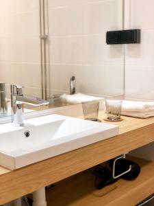 un bancone del bagno con lavandino bianco e specchio di HeseHotelli Turku Kaskentie a Turku