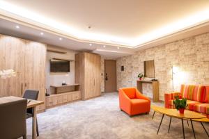 a living room with an orange couch and a table at Maximus Hotel Byblos in Jbeil