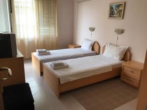 a hotel room with two beds and a television at Sea House in Sveti Vlas