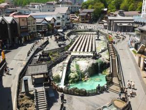 an amusement park with a waterfall in a town at Kusatsu Onsen Hotel Village in Kusatsu +37 photos