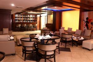 a restaurant with tables and chairs and a bar at Le Lac Sarovar Portico- Ranchi in Rānchī +62 photos